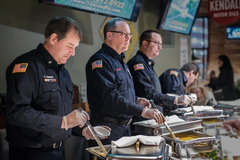 Men serving soup at event